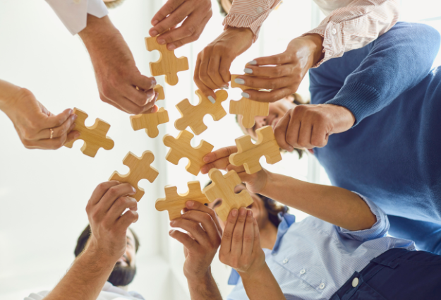 A group of people joining puzzle pieces together